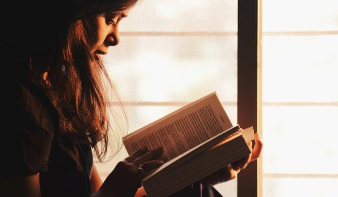 A girl reading a book to boost mental agility