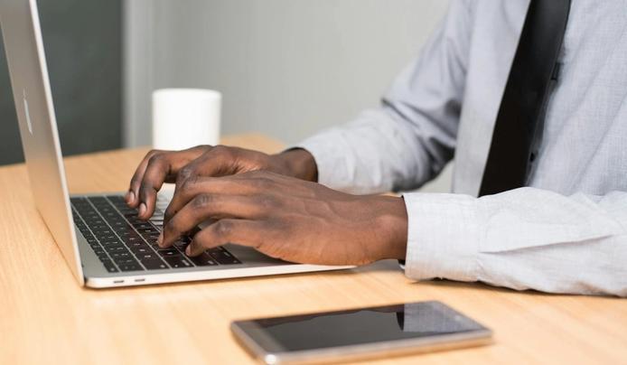 A person writing on a laptop