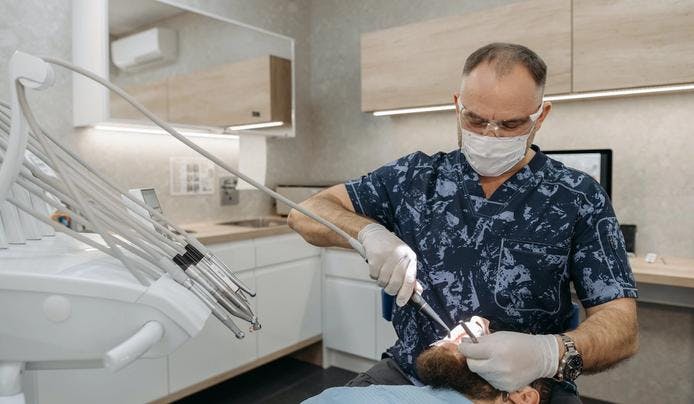 an image of a dentist working on a client