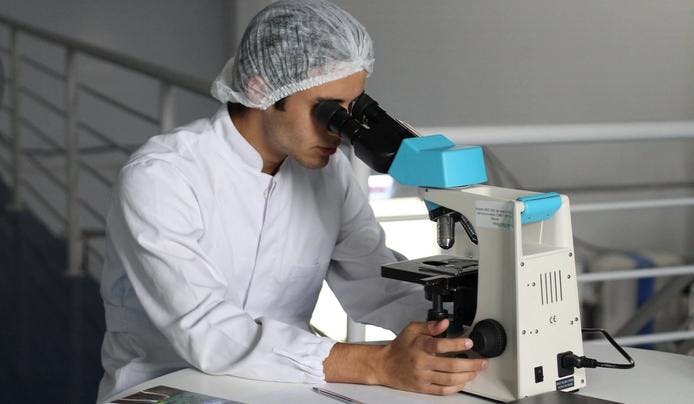 an image of a research scientist looking through a microscope