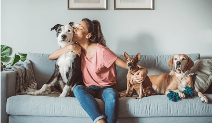 A women hugging her pet dogs